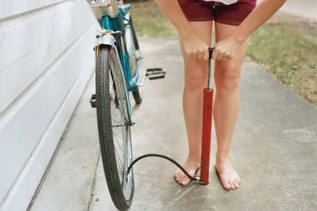 Person pumpt mit Luftpumpe Fahrrad auf